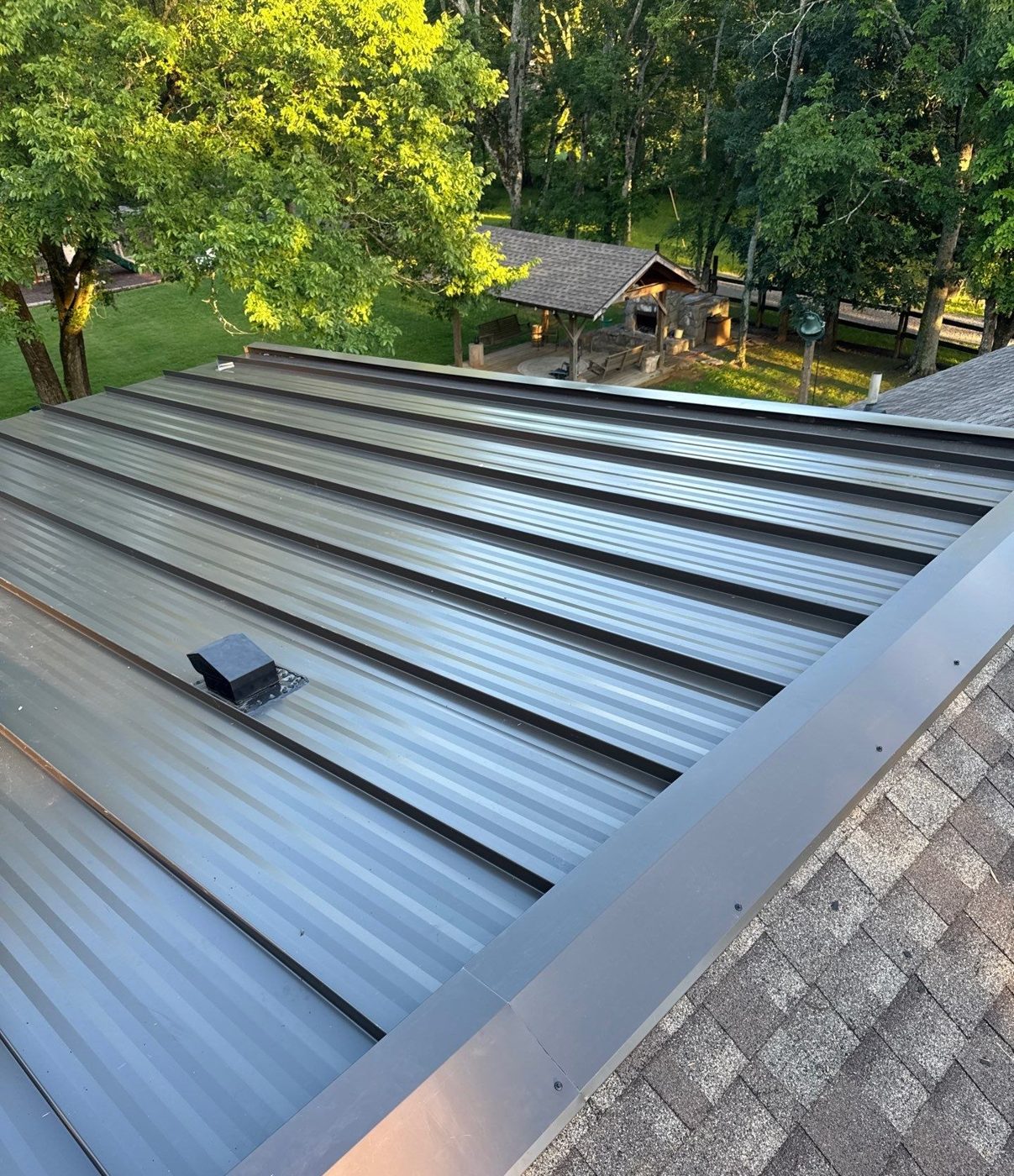 Dark bronze standing seam metal roof with stone chimney, private residence, Middle Tennessee